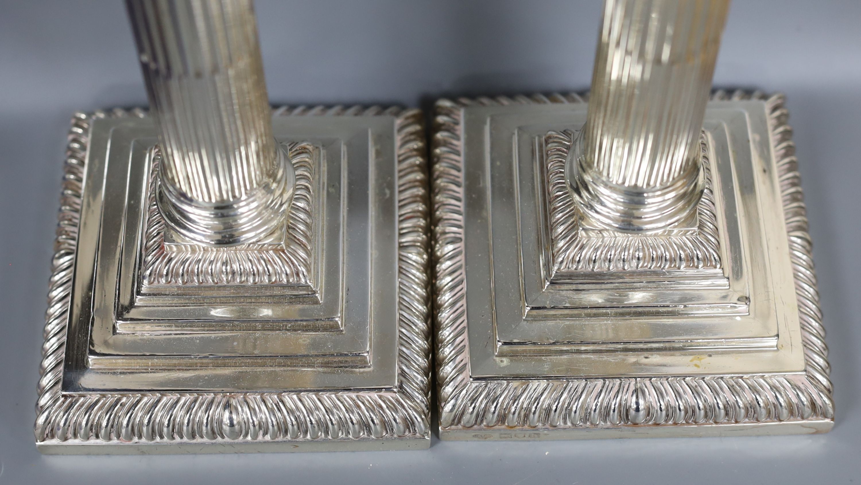 A pair of Edwardian silver Corinthian column candlesticks, Goldsmiths & Silversmiths Co Ltd, London, 1903, 27.4cm, weighted.